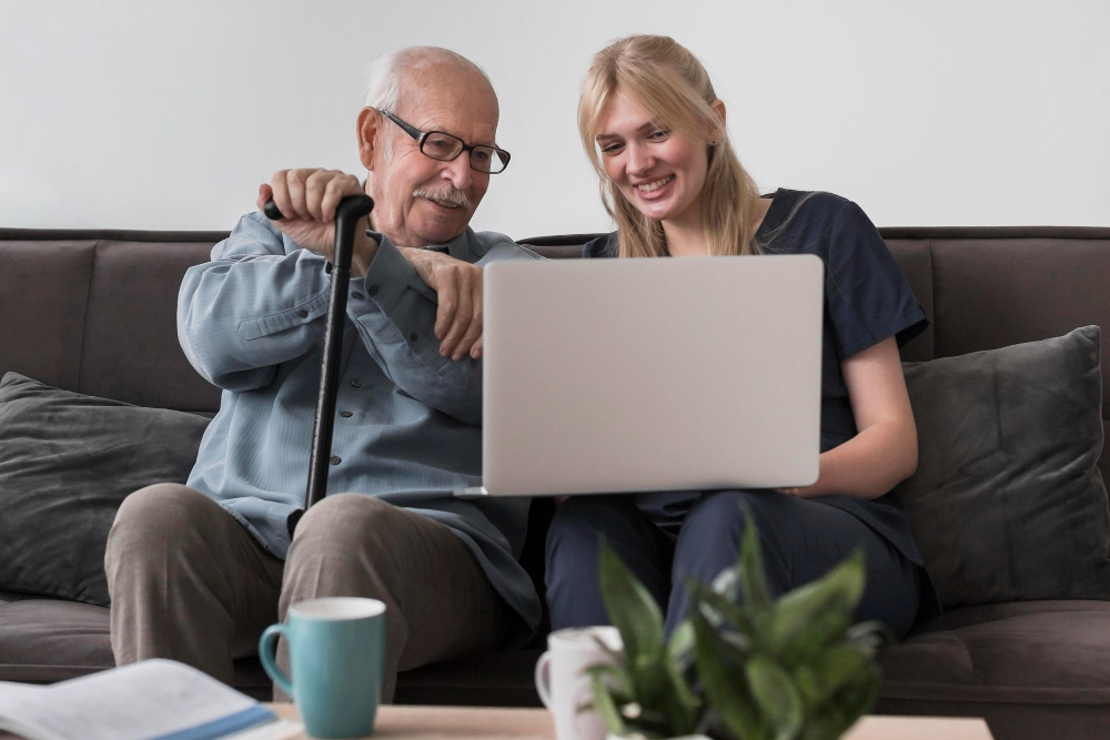 caregiver and elderly man using computer